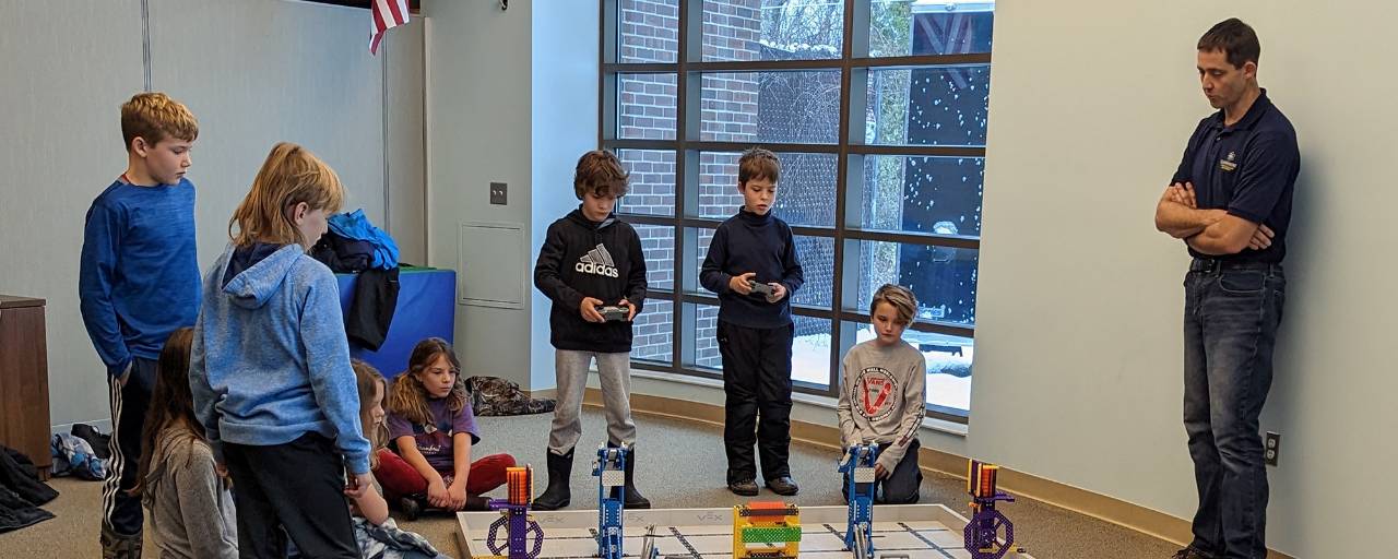 A group of boys test out small robots during an afterschool program.